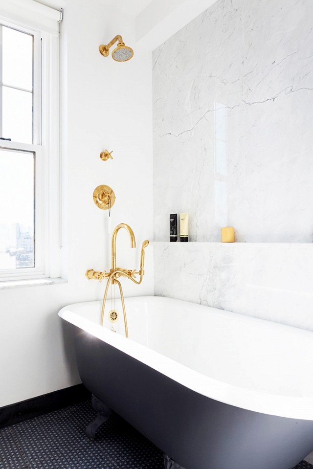 White and black bathroom finished with marble and gold fixtures.
