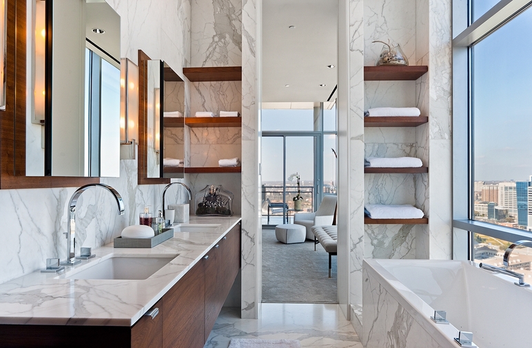 Modern high-rise bathroom design with cherry floating double bathroom cabinets, marble counter tops, marble tiles floor, marble walls backsplash, polished nickel faucets and chunky floating shelves.