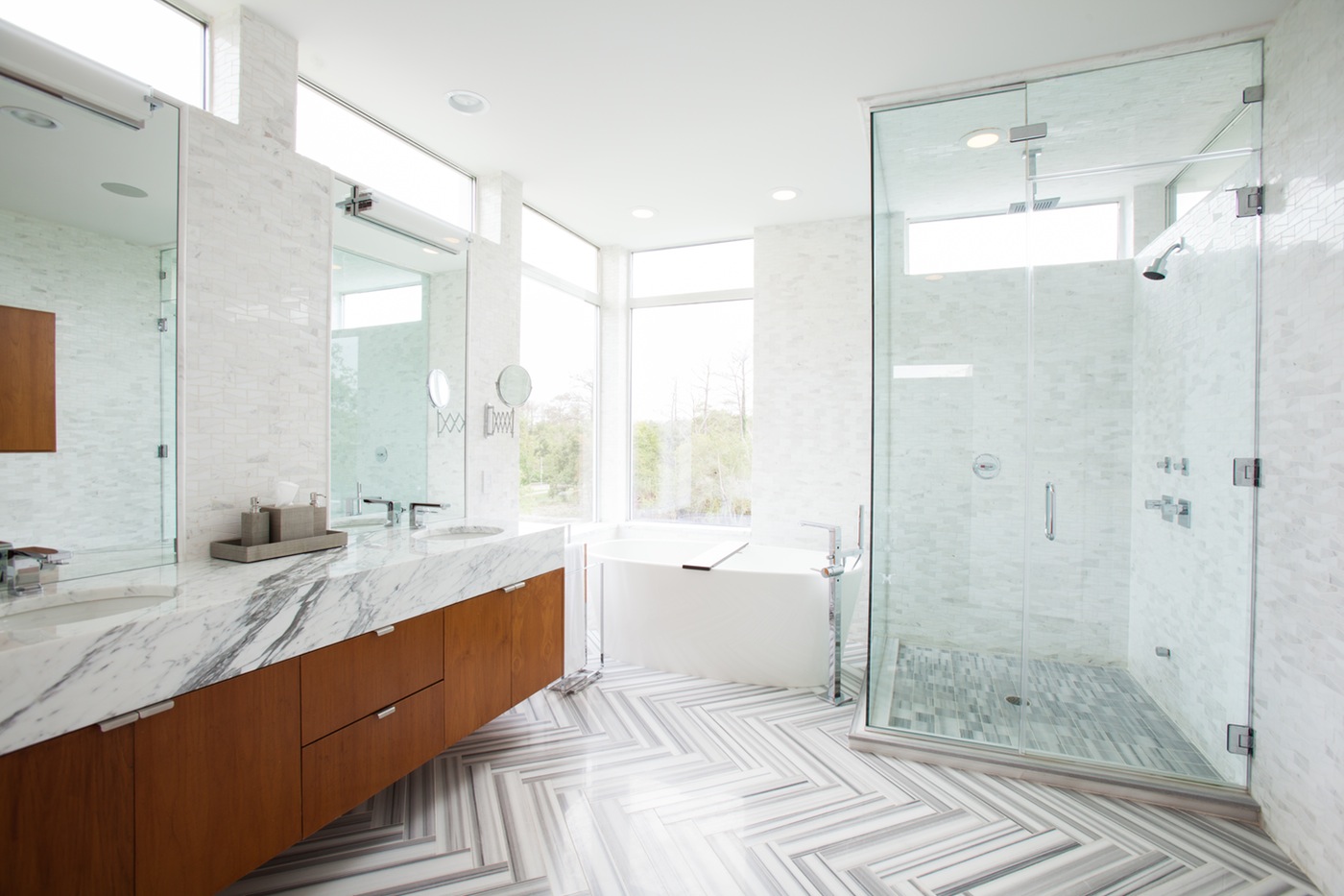 A spacious bathroom featuring a large-sized shower area with a walk-in shower and wood vanity.