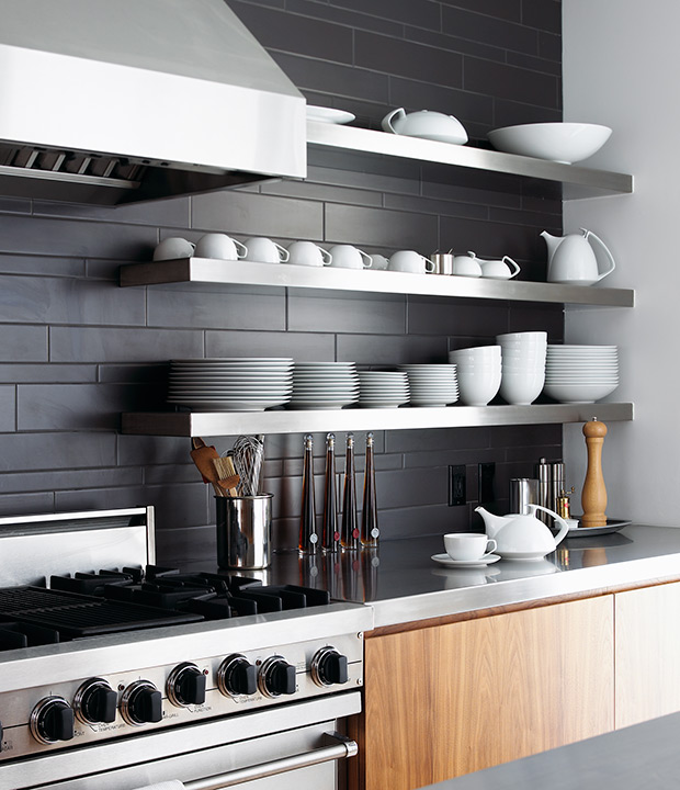 Charcoal ceramic tiles, walnut cabinetry and stainless steel shelves are a winning trio in this stylish kitchen.