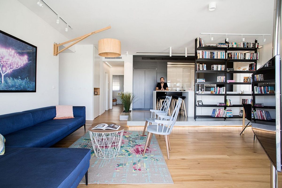 Open living area of the Israeli penthouse with a striking sectional in blue