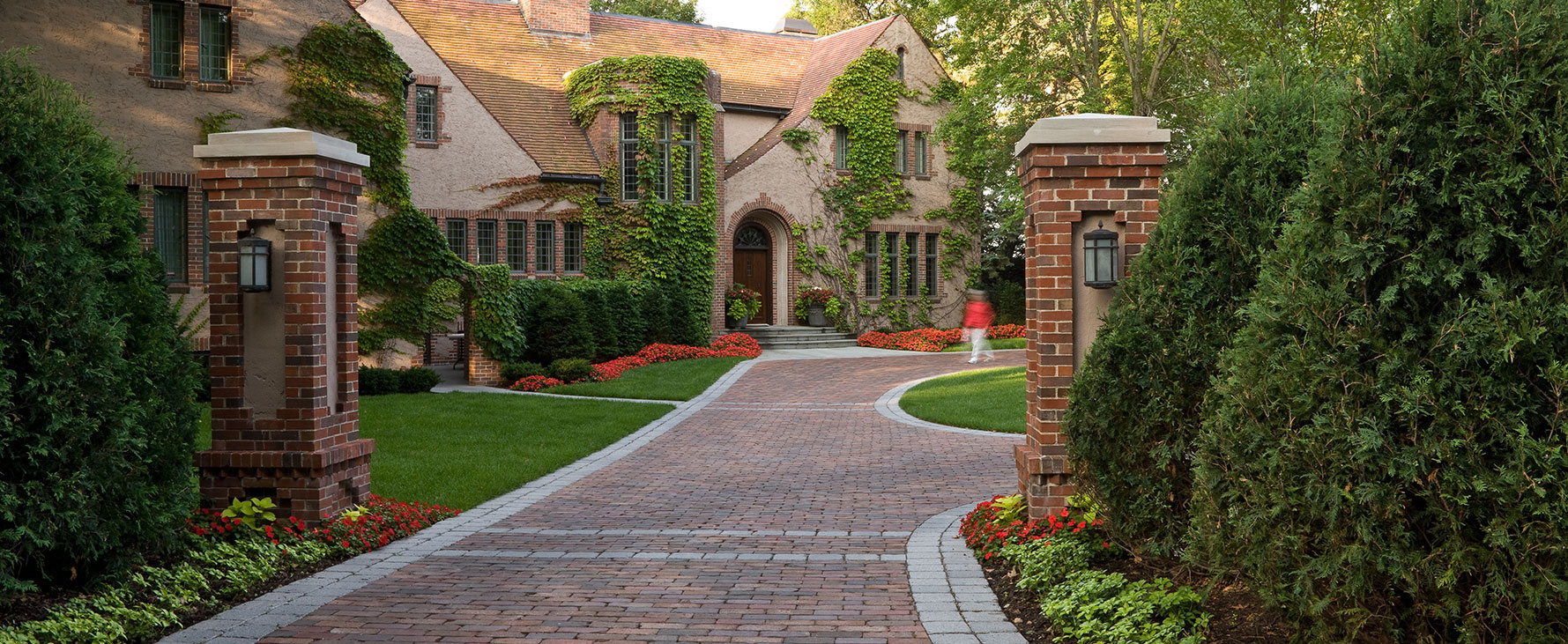 Red brick mansion with matching brick driveway.