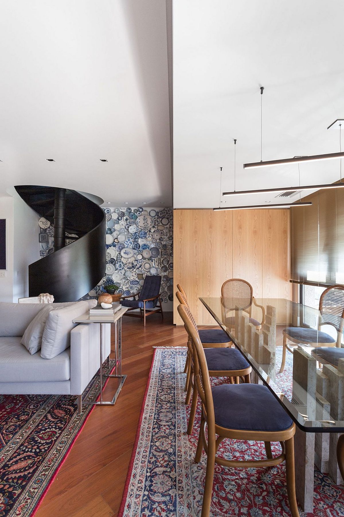 Rugs and accent wall covered with plates add pattern to the modern interior