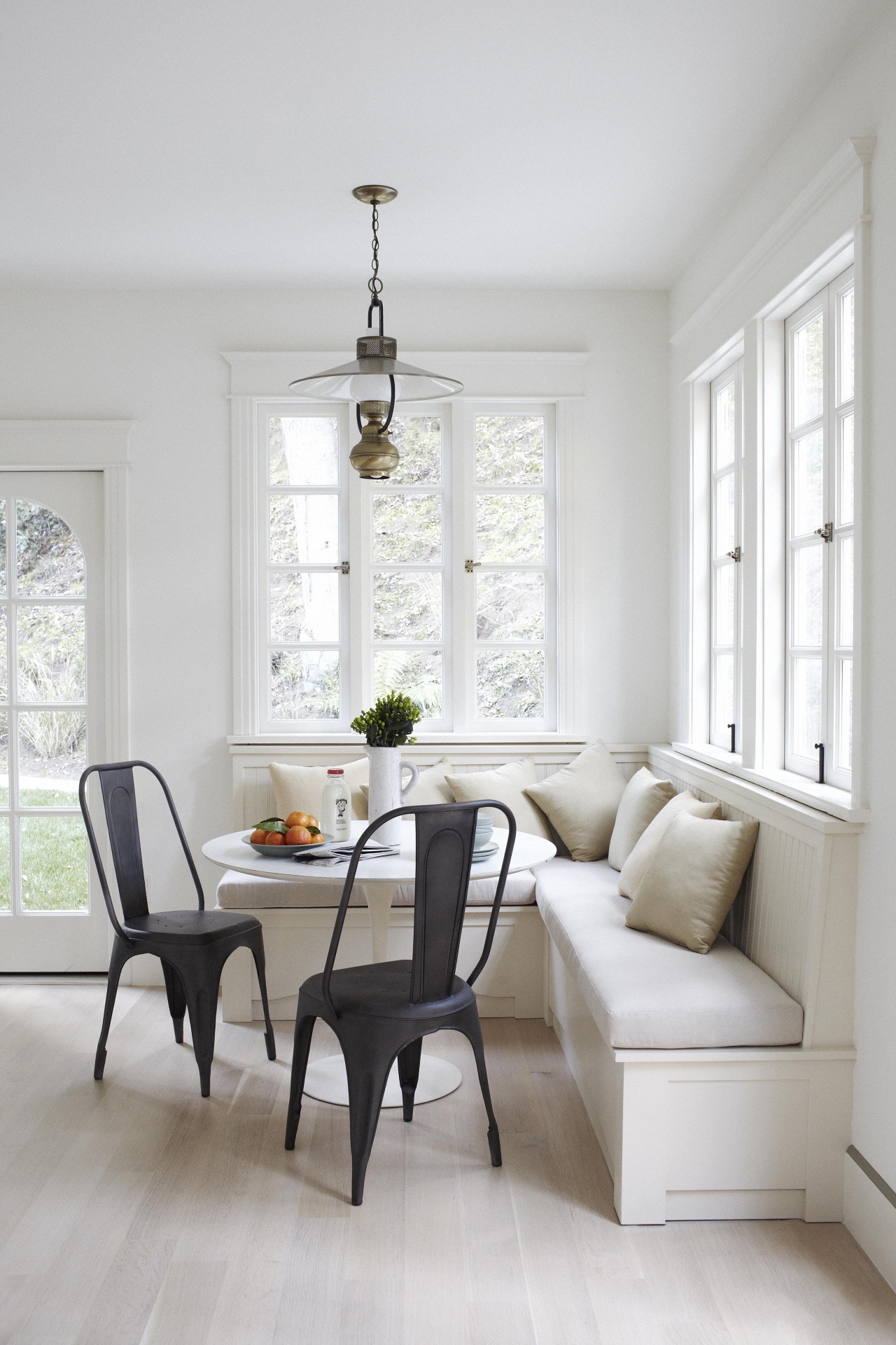 Simplistic banquette paired with dark chairs