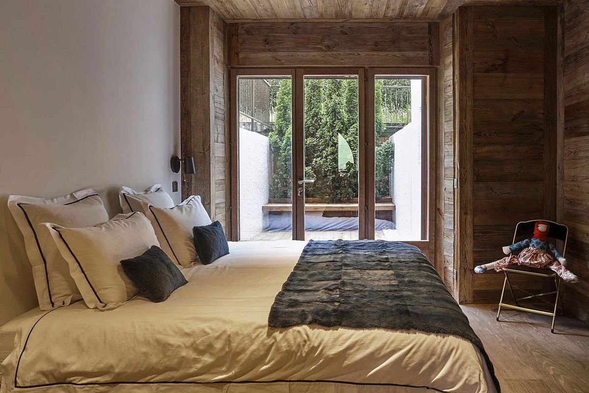 Small bedroom of the revamped French home connected with the balcony outside