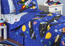 Space children's room with rocket-themed carpet, strip wallpaper, and bedding.