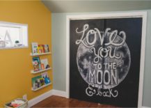 Space children's room with a yellow wall with hanging shelves and a chalkboard that reads "Love you to the moon & back."