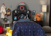 Space-themed children's room featuring a bed with a rocket headboards that reads the numbers 5 and 2 on either side.