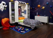 Space-themed child bedroom with planet artwork on the walls and a themed carpet.