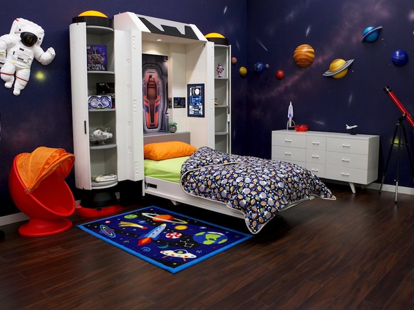 Quarto infantil com tema espacial, ilustrações de planetas nas paredes e tapete temático.
