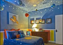 Space children's room is painted blue and has planets hanging from the ceiling.