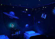 Child bedroom with a space theme, featuring planets, sun, and satellite on the wall paper.