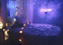 Space children's room with star-themed yellow lights and a bright purple neon sign that reads "dreamer."