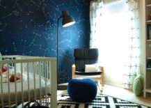 Space-themed nursery with white crib and space wallpaper.