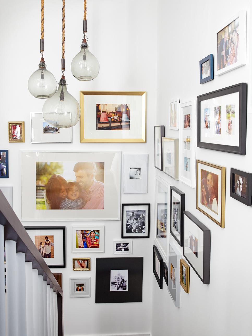Corner stairway with lots of framed pictures and lamps.