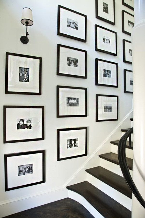 Stairway gallery with black and white pictures in black frames.