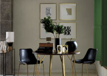 A sleek black and gold dining table is the centerpiece of the image. Two matching chairs are pulled up to the table.