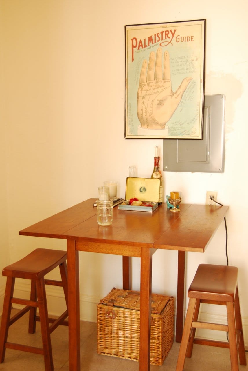 A wooden table with a smooth surface is accompanied by two stools that are placed on opposite sides.