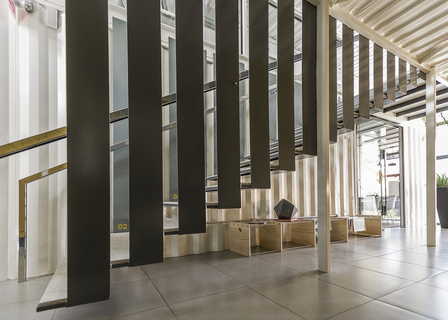 Utilizing the space underneath the sculptural staircase with a stylish magazine rack