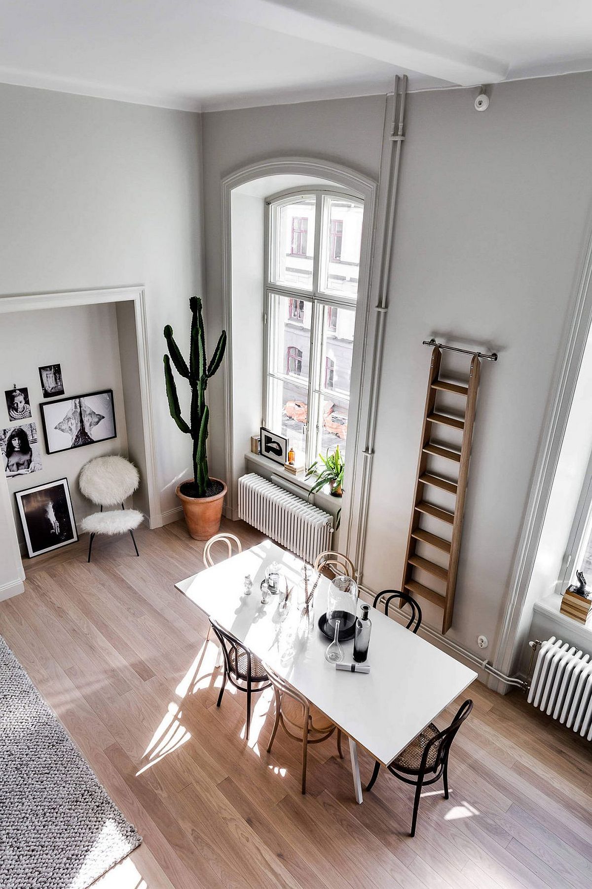 View of the small, light-filled dining area of the Scandinavian style apartment with a ladder