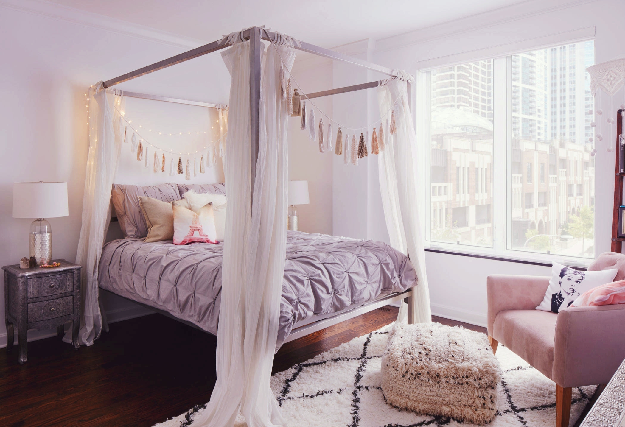 A cozy bohemian nook with white curtains around the bed frame