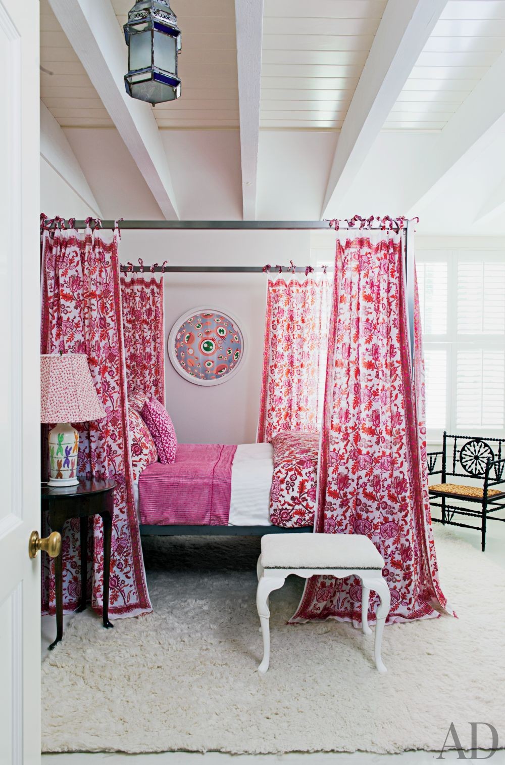 Boho pink four poster bed as the centerpiece of the room