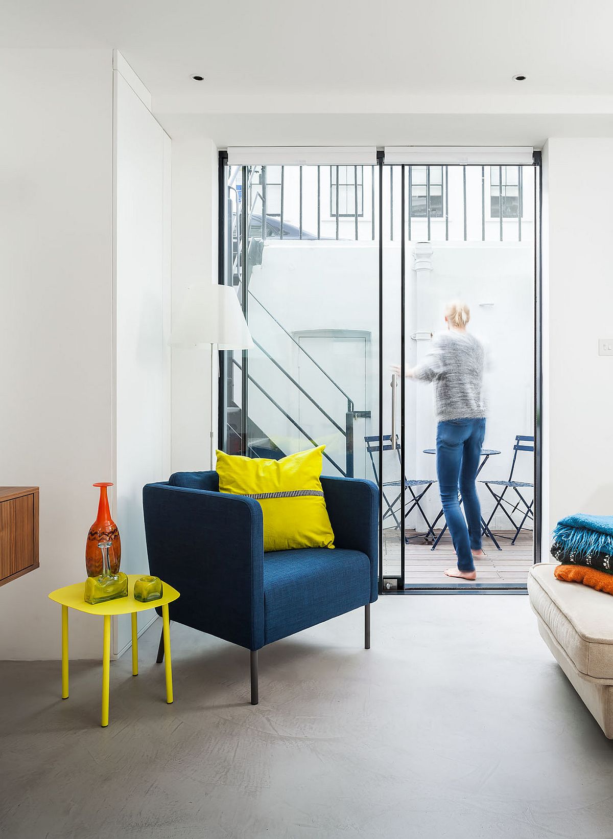 Club chair in blue and accents in yellow add color to the neutral interior