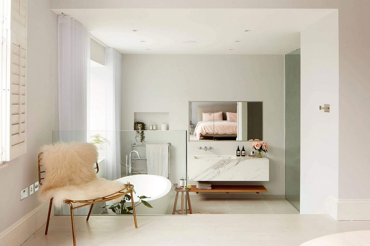 Contemporary bathtub in white, marble vanity and pops of pink create a chic master bath