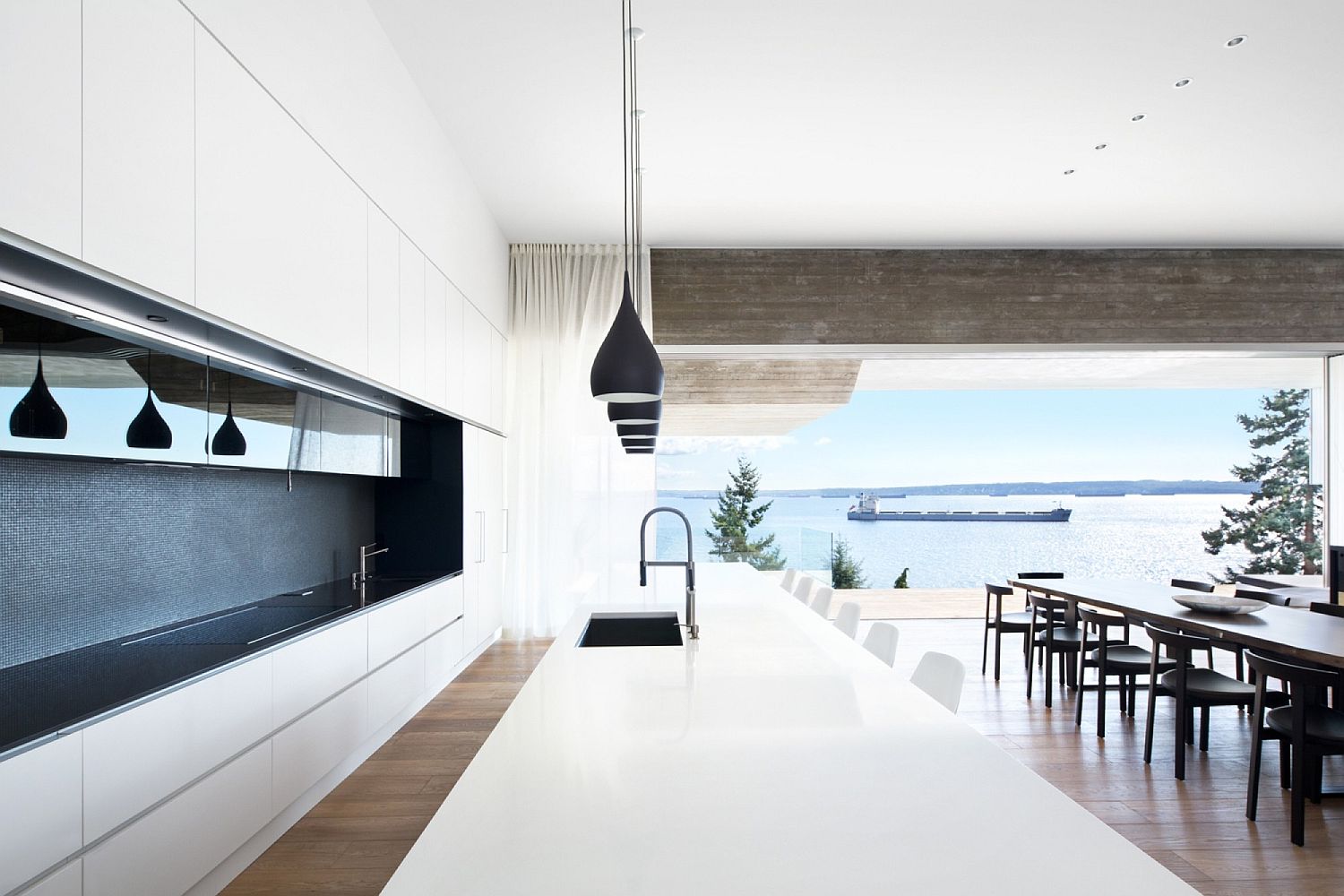 Dashing-minimal-kitchen-in-whit-with-large-island-and-black-pendant-lights