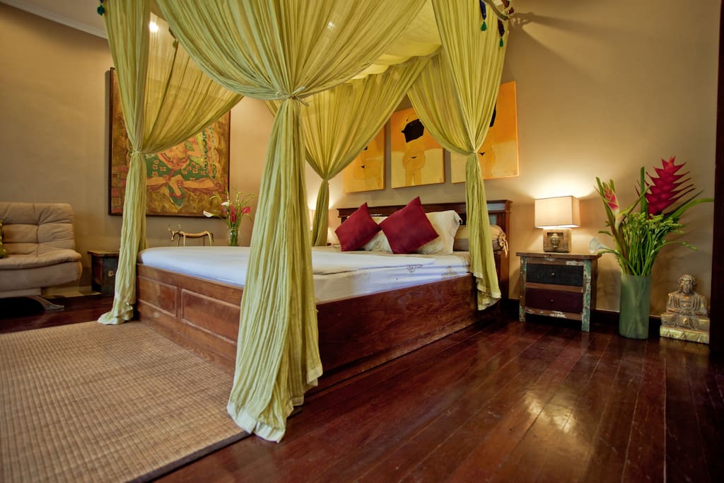 Four poster bed with a colorful canopy channeling wilderness