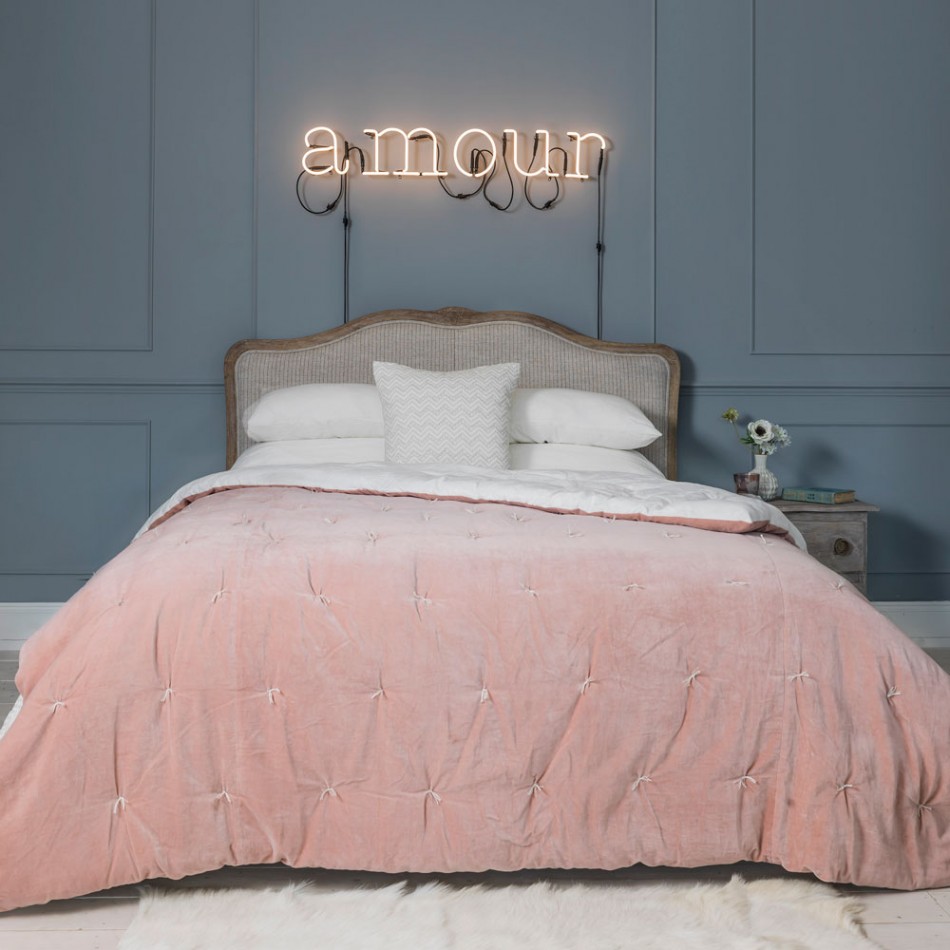 Gentle rosy bedroom with Amour neon sign