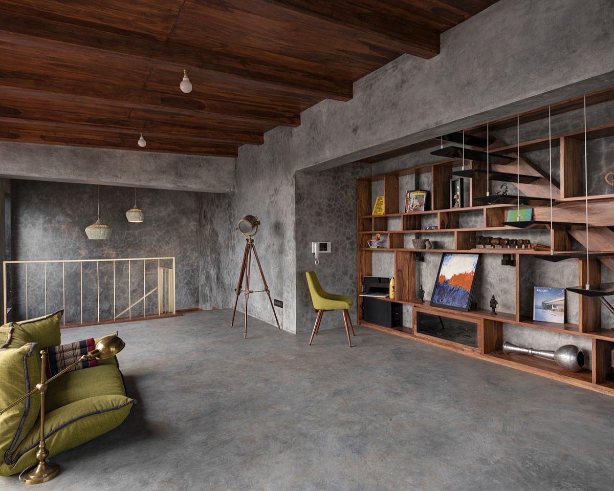 Home library and office with wooden shelving unit and comfy seating