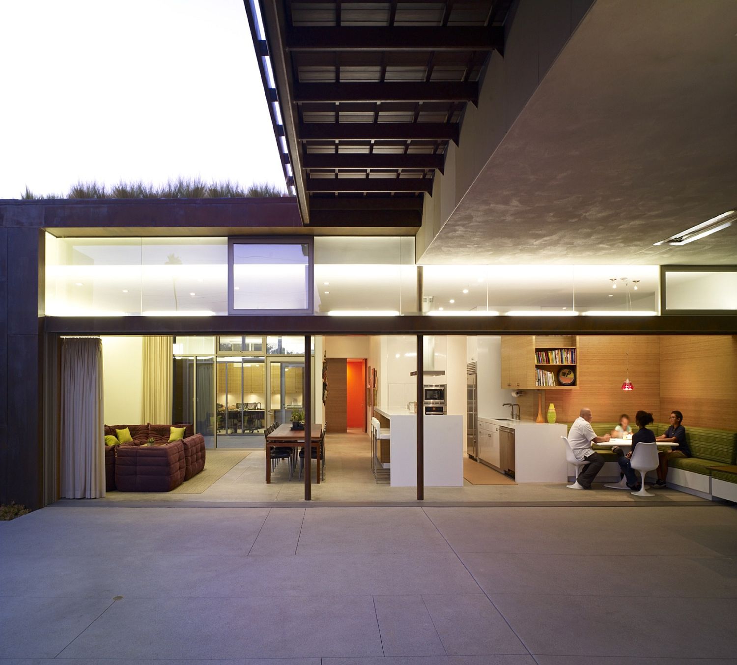 Kitchen and dining area of the home flows into the pool area and deck