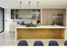 Large-kitchen-island-with-a-white-countertop-and-glass-cabinets-in-the-backdrop-217x155