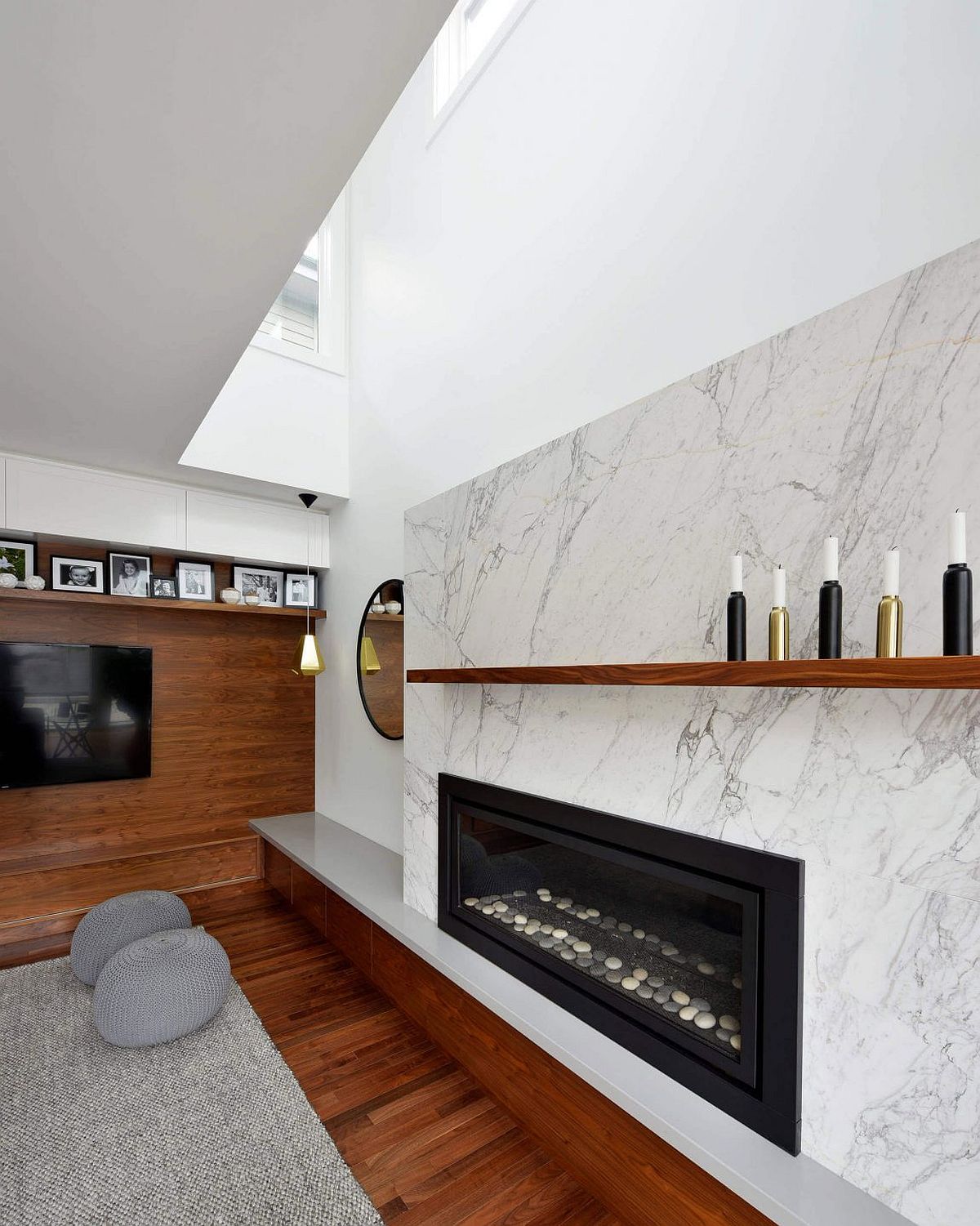 Marble around the fireplace along with the wooden TV wall bring in textural contrast