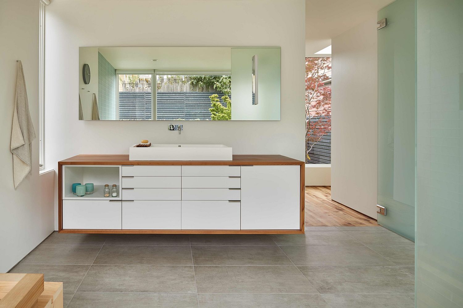 Modern bathroom vanity with wood surround and matching mirror above