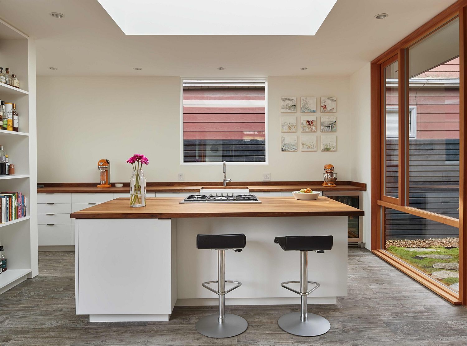 Modern kitchen in white with wooden countertops and ample natural lighting