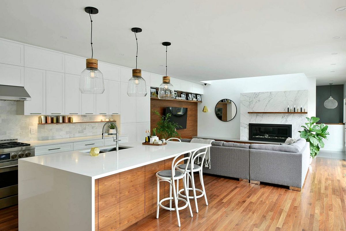 Open living area with kitchen in white and smart pendant lights