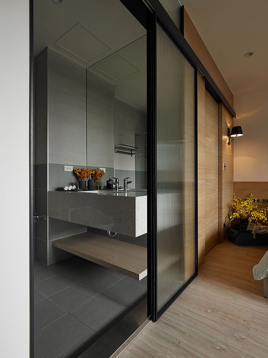 Sliding trasulucent glass doors connect the bathroom with the bedroom