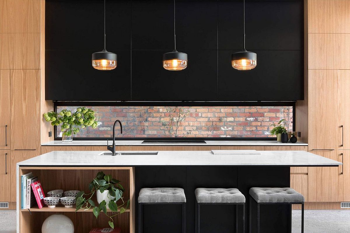 Small window above the the kitchen counter brings the brick wall aesthetic indoors