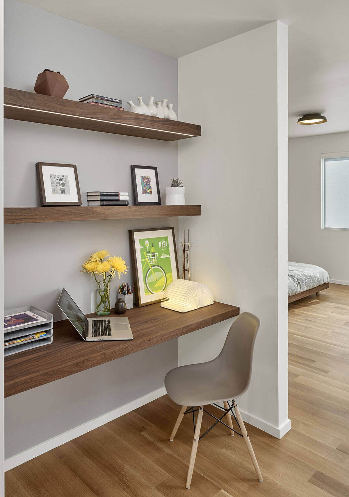 Small workspace in the bedroom corner with floating wooden shelves