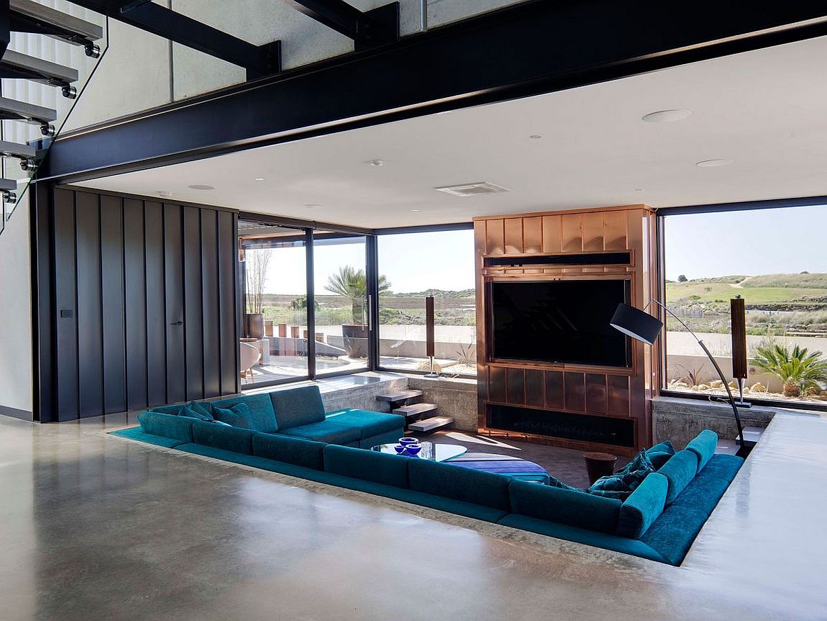 Sunken living room sitting area with a plush blue couch