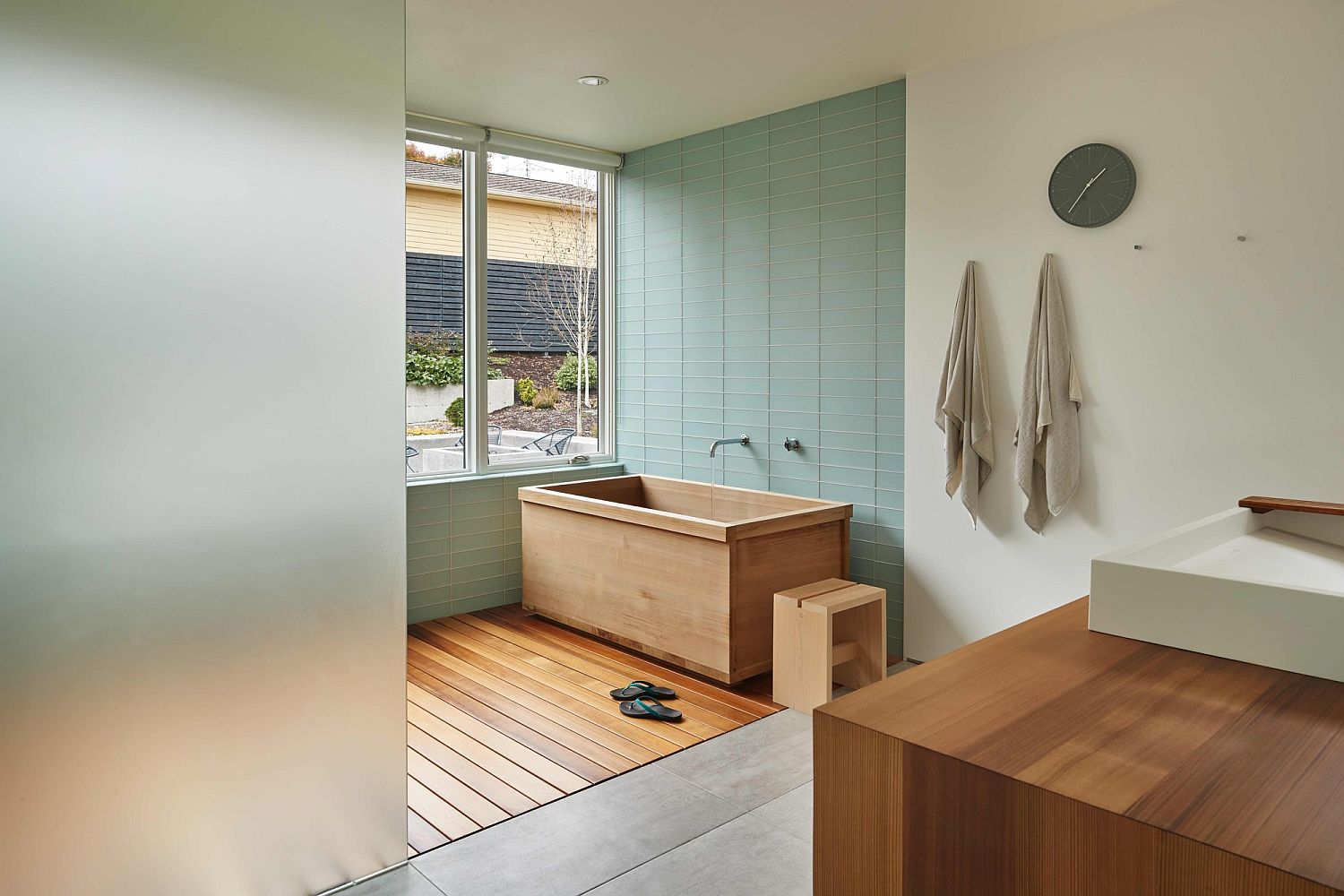 Wooden bathtub in contemporary bathroom in white and pastel blue