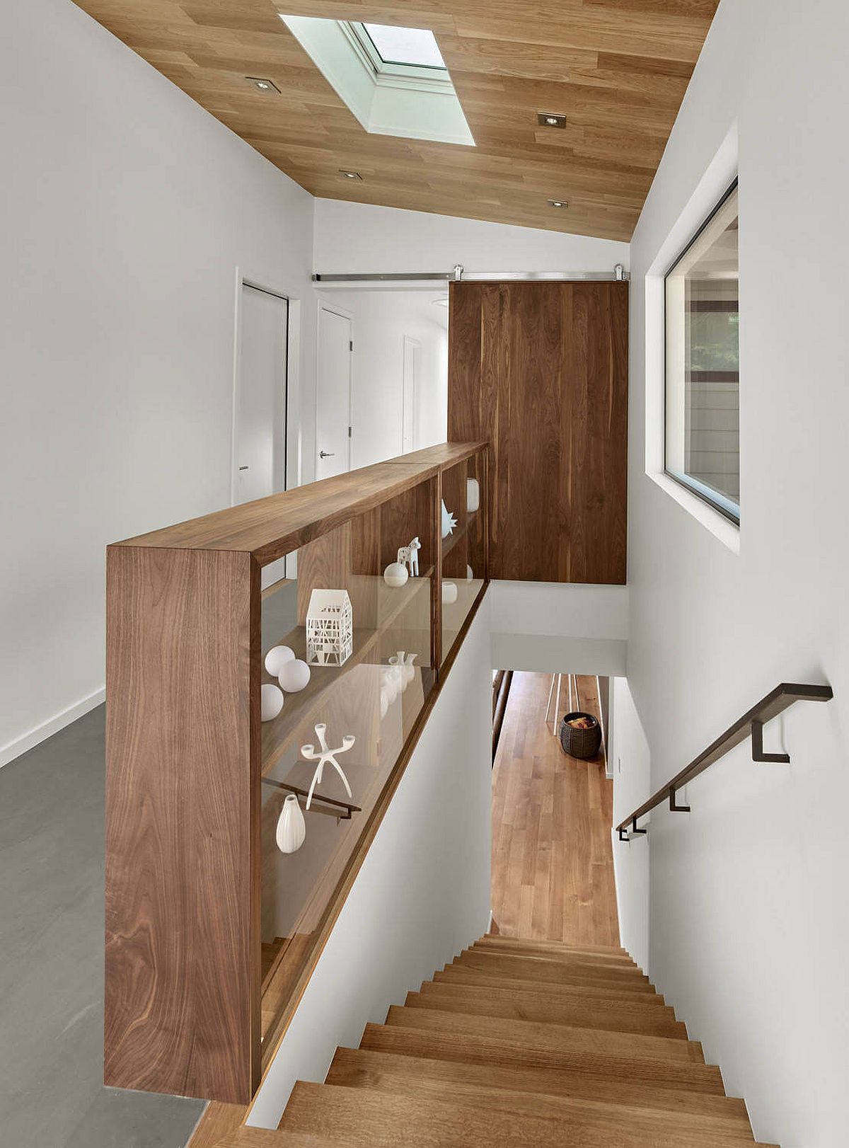 Wooden shelf next to the staircase also doubles as a railing