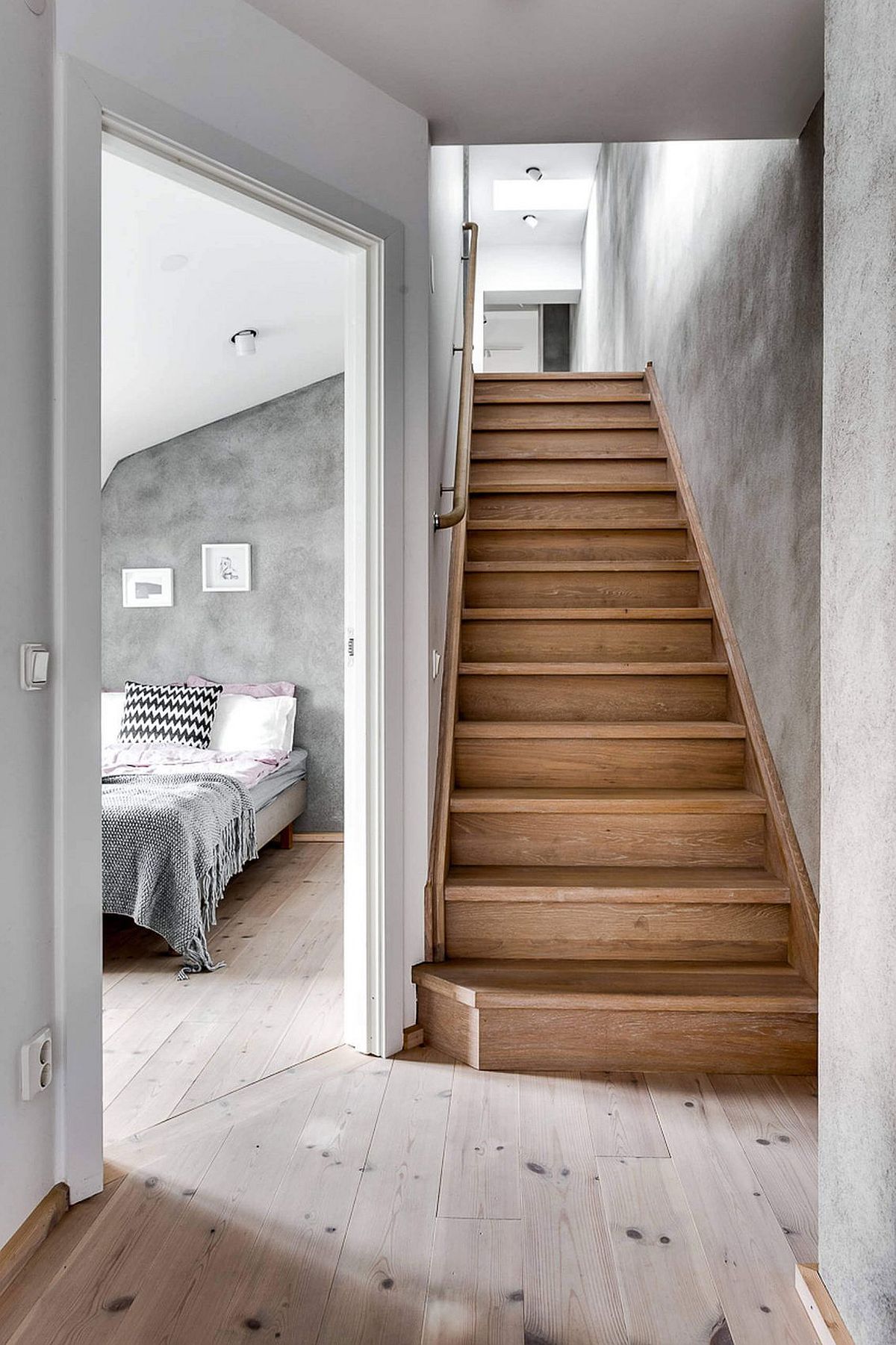 Wooden staircase leading to the ebdroom of the Scandinavian apartment