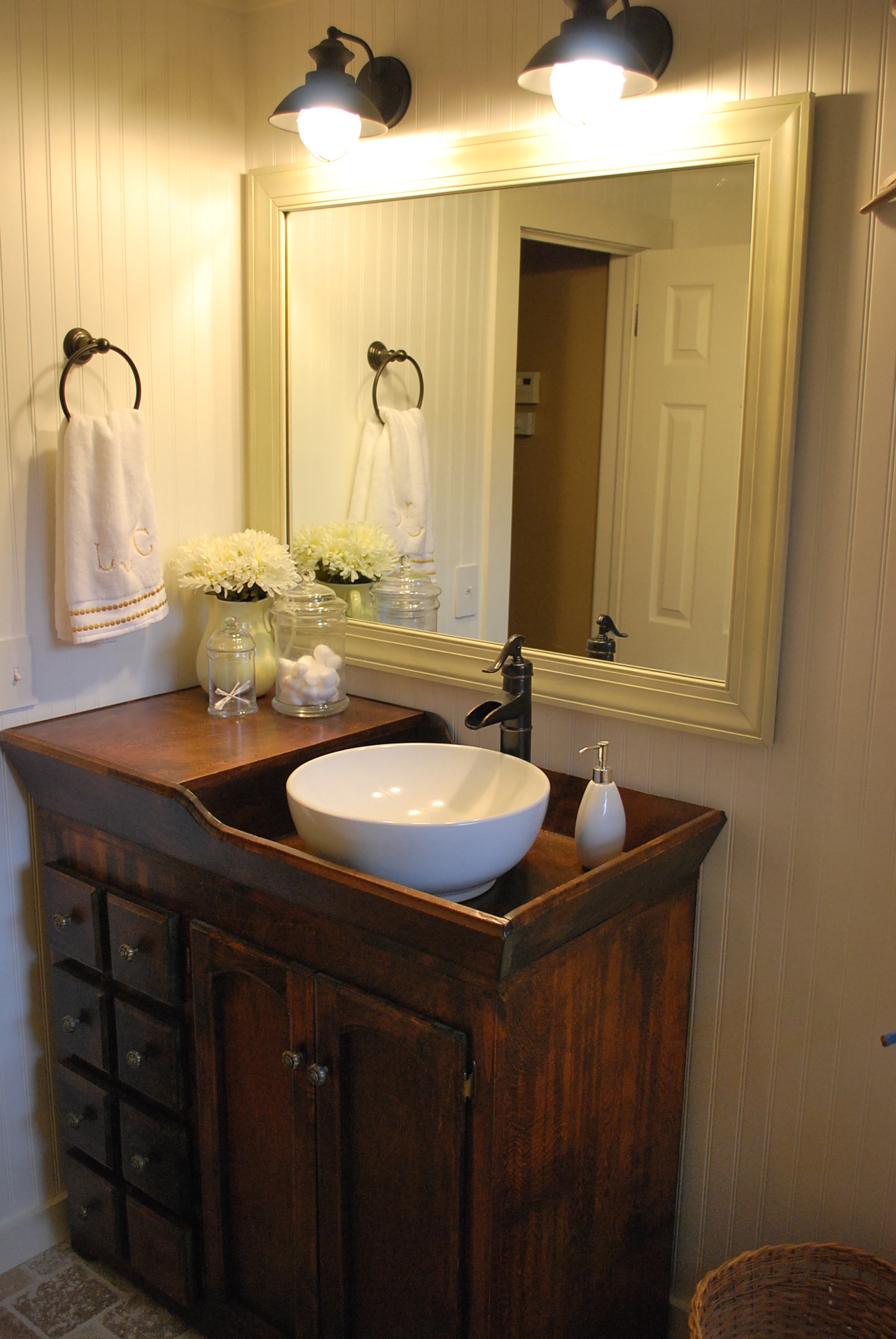 A simple white vessel sink set on a rustic table