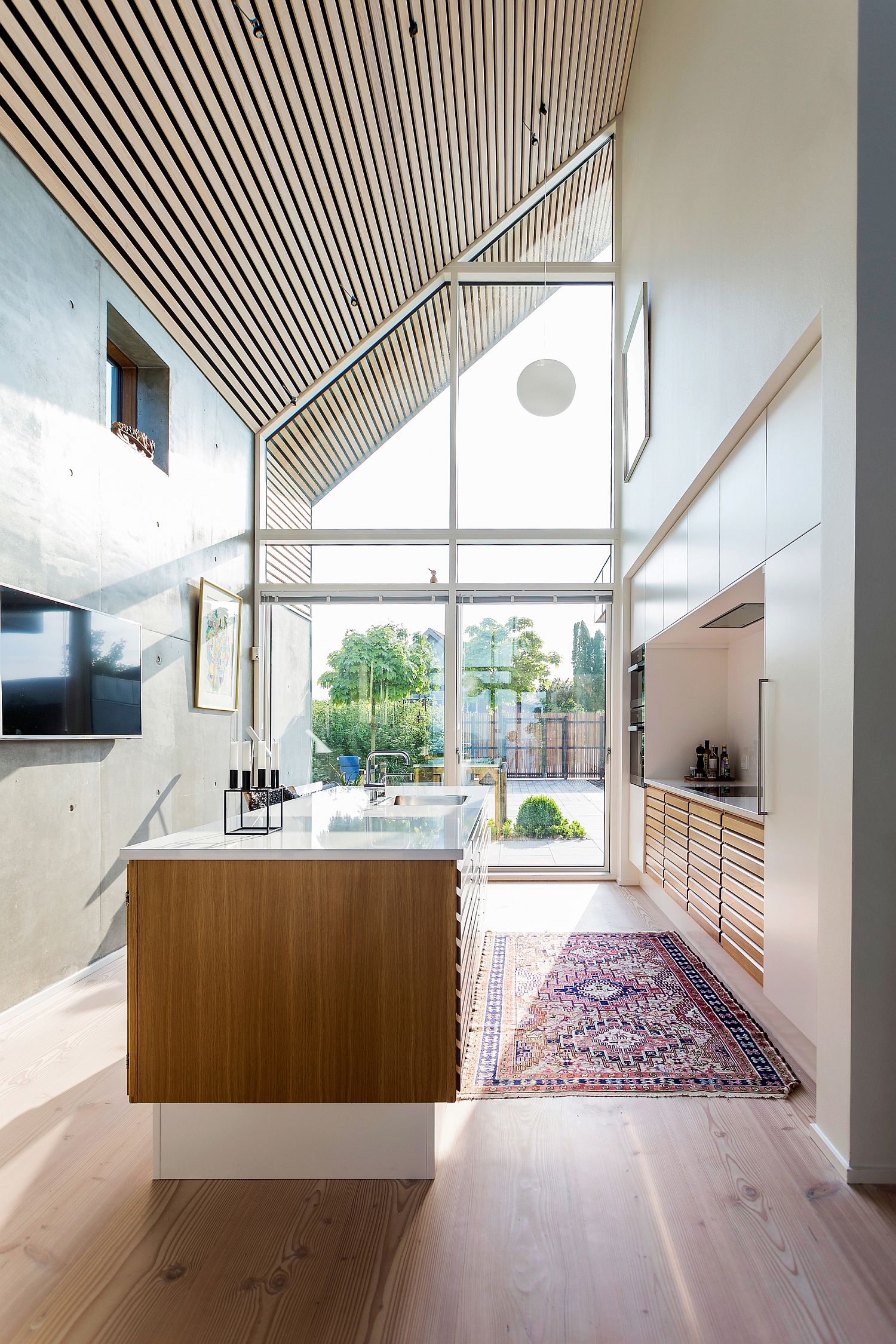 Angular roof, large glass windows and high ceilings give the interior an airy, modern appeal