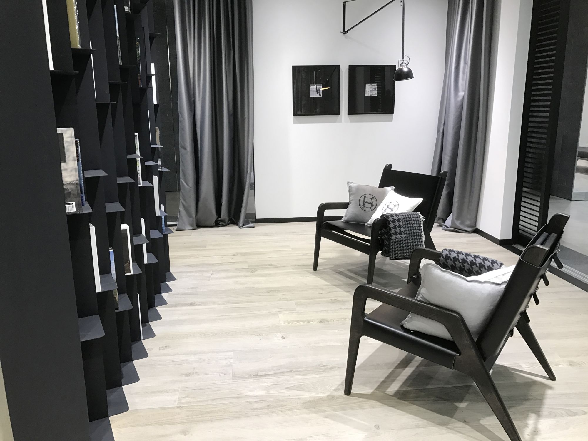 Black and white lounge area with bright wood inspired floor tiles - by Porcelanosa