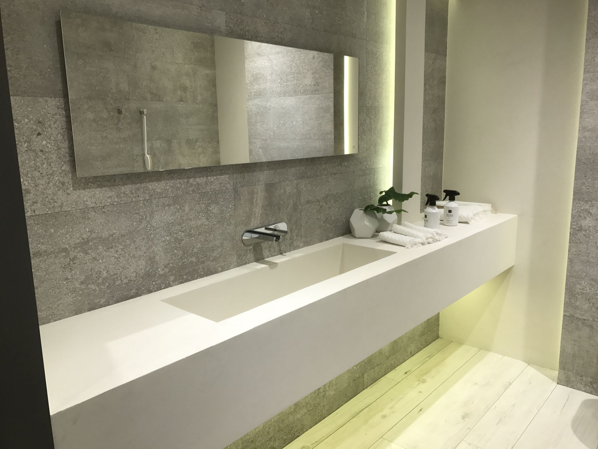 Concrete inspired wall tiles with white large bathroom sink by Porcelanosa