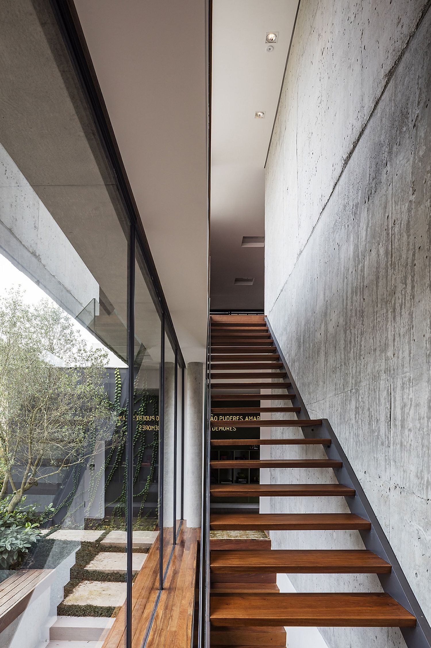 Contemporary wooden stairway with concrete wall next to it